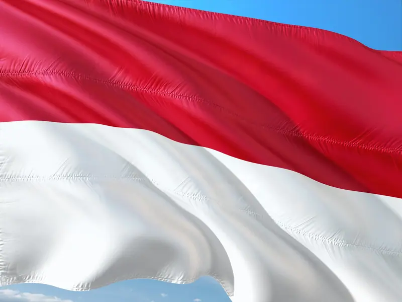 The red and white Indonesian flag waving, backdrop for an index of crypto buying guides by city