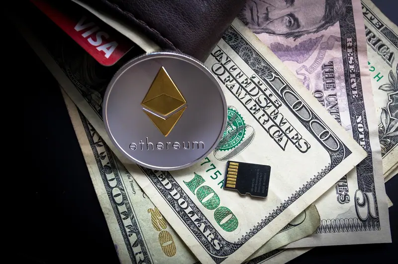 Koin Ethereum di samping kartu bank dan uang dolar, ilustrasi biaya dan pajak transaksi crypto